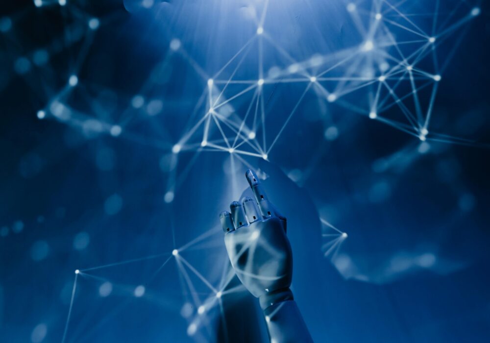 Free A robotic hand reaching into a digital network on a blue background, symbolizing AI technology. Stock Photo