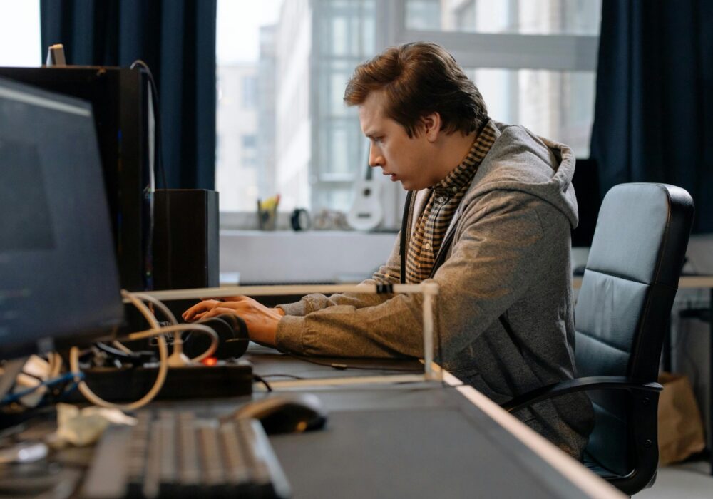 Free A concentrated professional working at a computer in a modern office setting. Stock Photo
